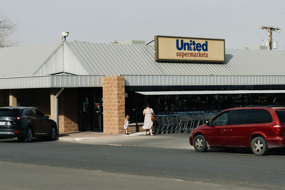 A women and a child walk into a supermarket